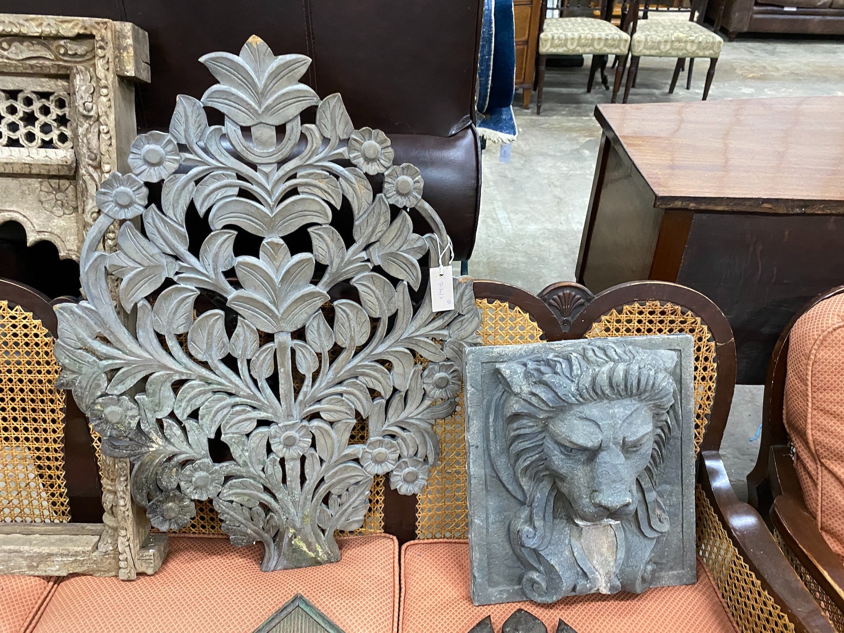 A carved Eastern hardwood window frame, height 82cm, a composition lion mask wall fountain two spoon racks and a composition wall hanging